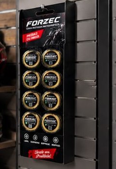 Exhibidor FORZEC colgado en un panel ranurado de una tienda de motos